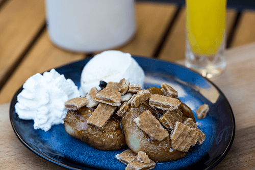 Gegrilde perzik met vanille-ijs, karamelsaus en stroopwafel crumble